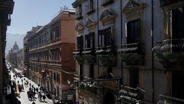 Una veduta di una strada con edifici, balconi e cielo sereno.