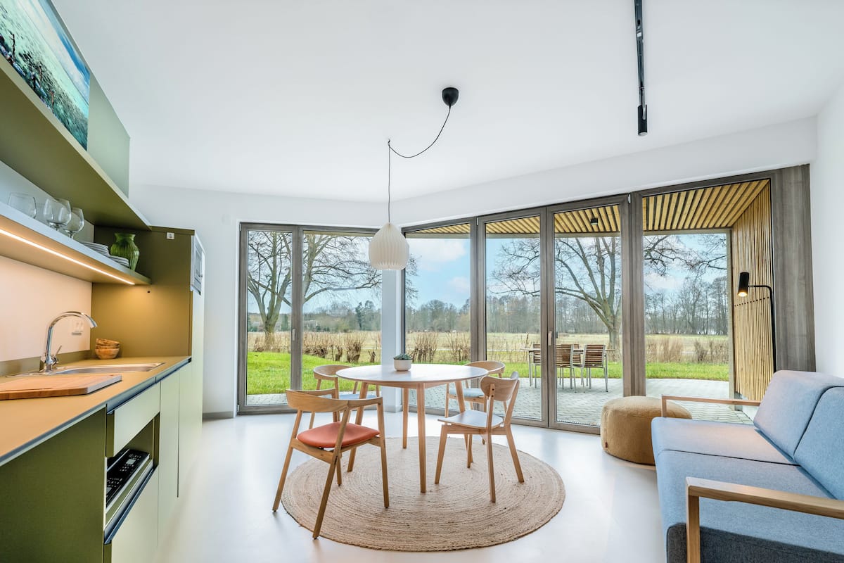 Una cocina moderna con comedor, ventanas amplias y vistas al exterior.
