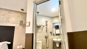 A bathroom with a shower, toilet, sink, and a mirror. - The Snooze Hotel Bugis (Singapore)
