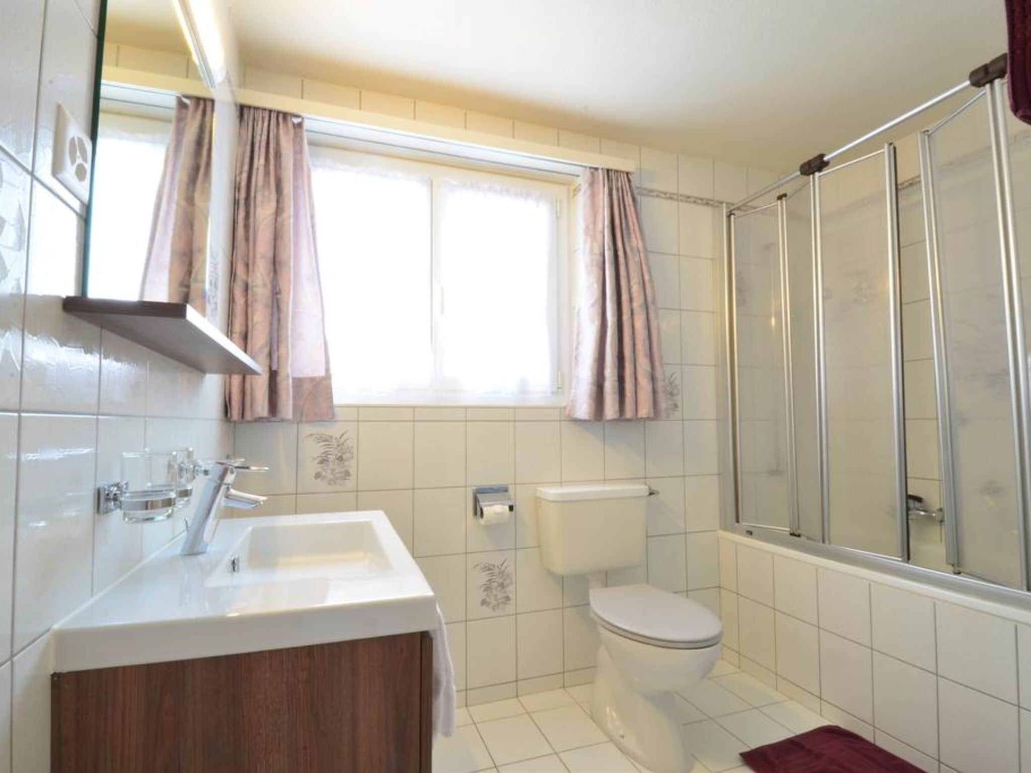A bathroom with a toilet, sink, and shower.
