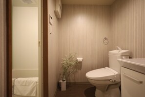 Habitación básica con 2 camas individuales | Baño | Tina con regadera, regadera tipo lluvia, amenidades de baño gratuitas 