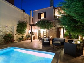 A courtyard with a swimming pool, outdoor furniture, and a stone wall. - Villa Agriolive  (Hersonissos)