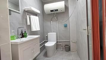 A modern bathroom with a toilet, sink, and shower.