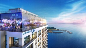 A high-rise building with a glass facade and a sign reading "SURF RESORT JD".