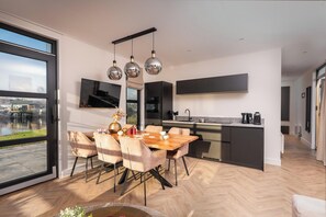 Una cocina moderna con comedor, ventanas amplias y vistas al exterior.