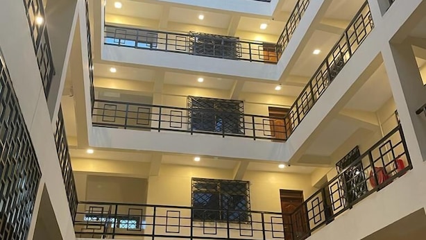 A multi-level atrium with balconies, a central open space, and a van parked at the bottom.