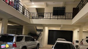 A multi-level parking garage with two cars parked on the ground floor.