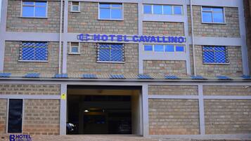 A multi-story building with a sign reading "HOTEL CAVALLINO".