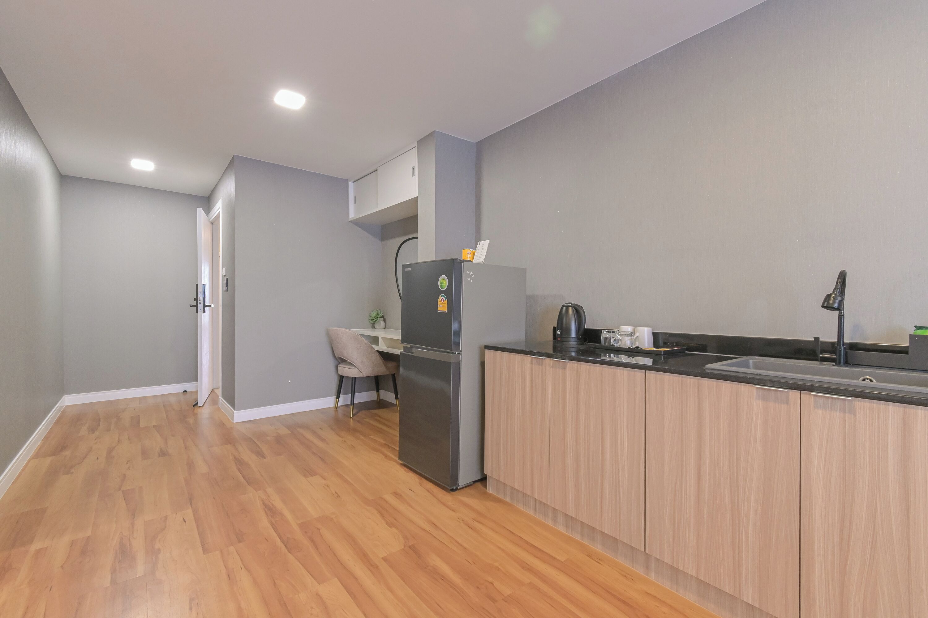 A modern kitchen with a built-in refrigerator, wooden cabinets, and a black countertop.