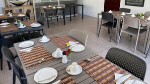Ein Restaurant mit gedeckten Tischen, einer Theke mit Speisekarte und einem Schild, das den Zugang nur für Personal kennzeichnet.
