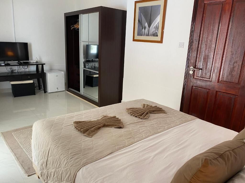 Un dormitorio con cama, armario, escritorio y puerta.