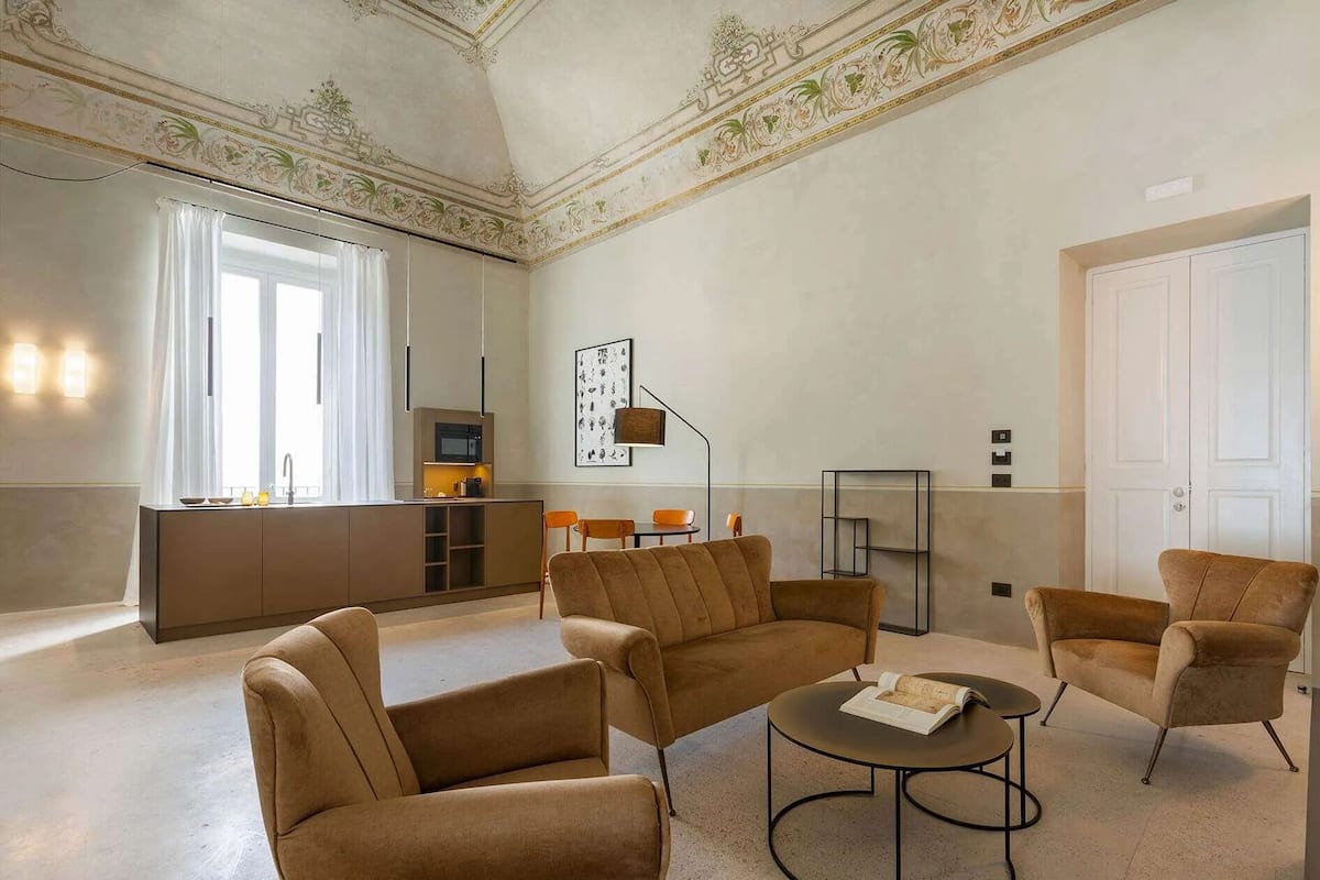 Amplia sala de estar con un conjunto de sofás, una mesa de centro y un comedor.