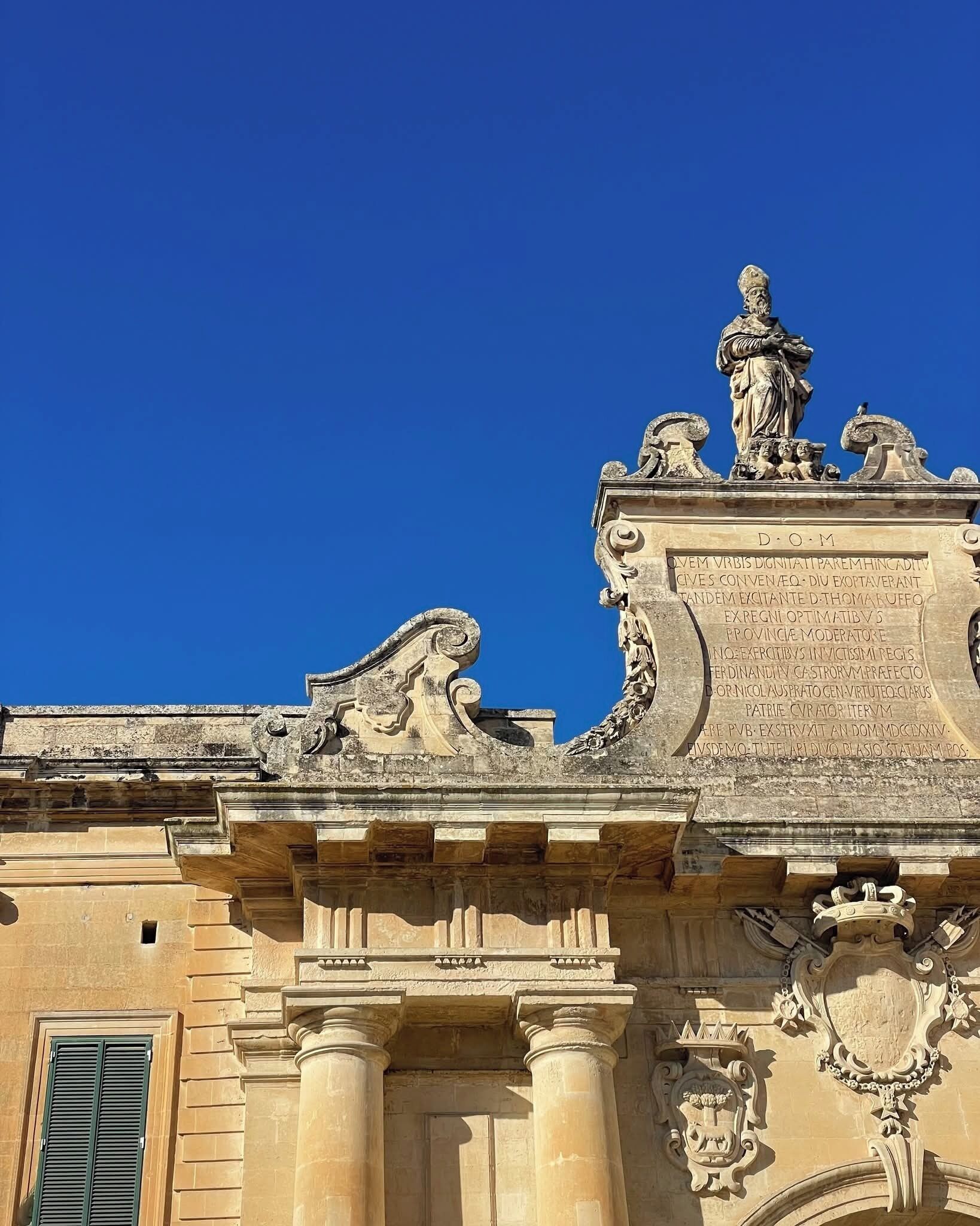 Un bâtiment à l’architecture classique, orné de sculptures élaborées et de sculptures en relief détaillées sur la façade.