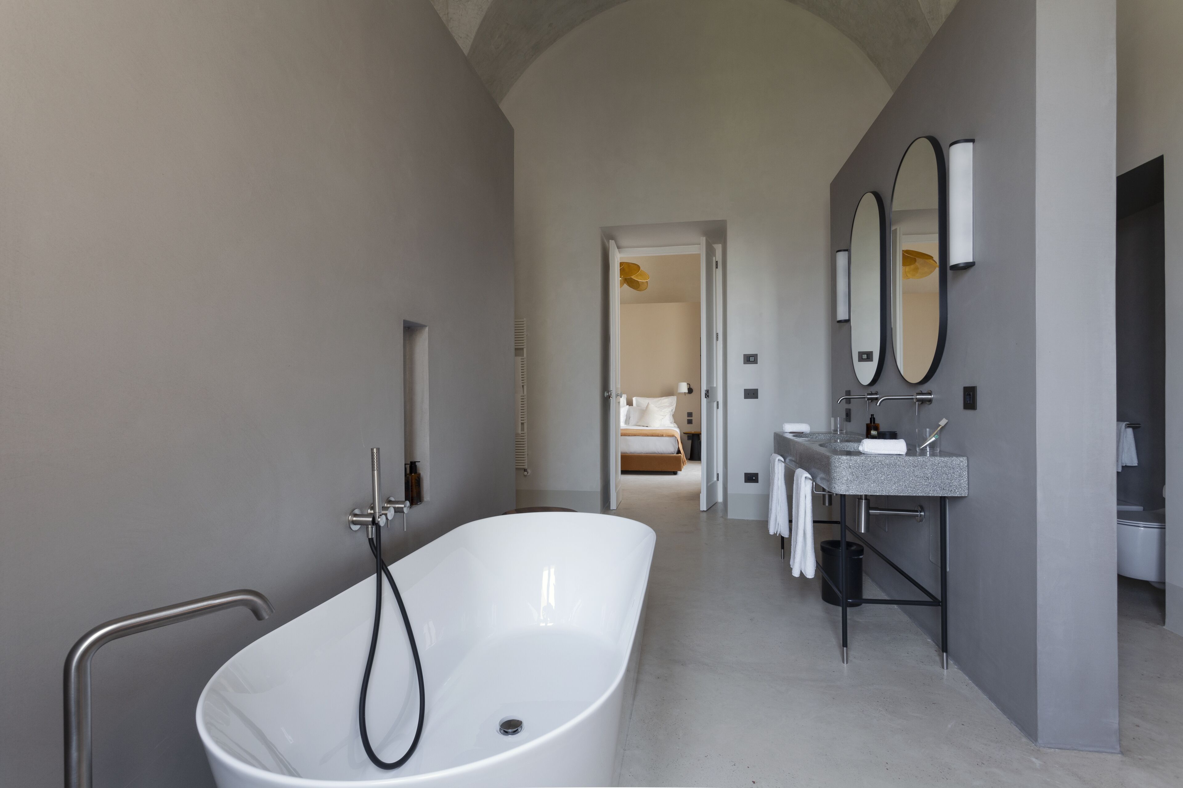 Une salle de bain moderne avec une baignoire sur pieds, un meuble-lavabo avec un miroir et un espace douche.