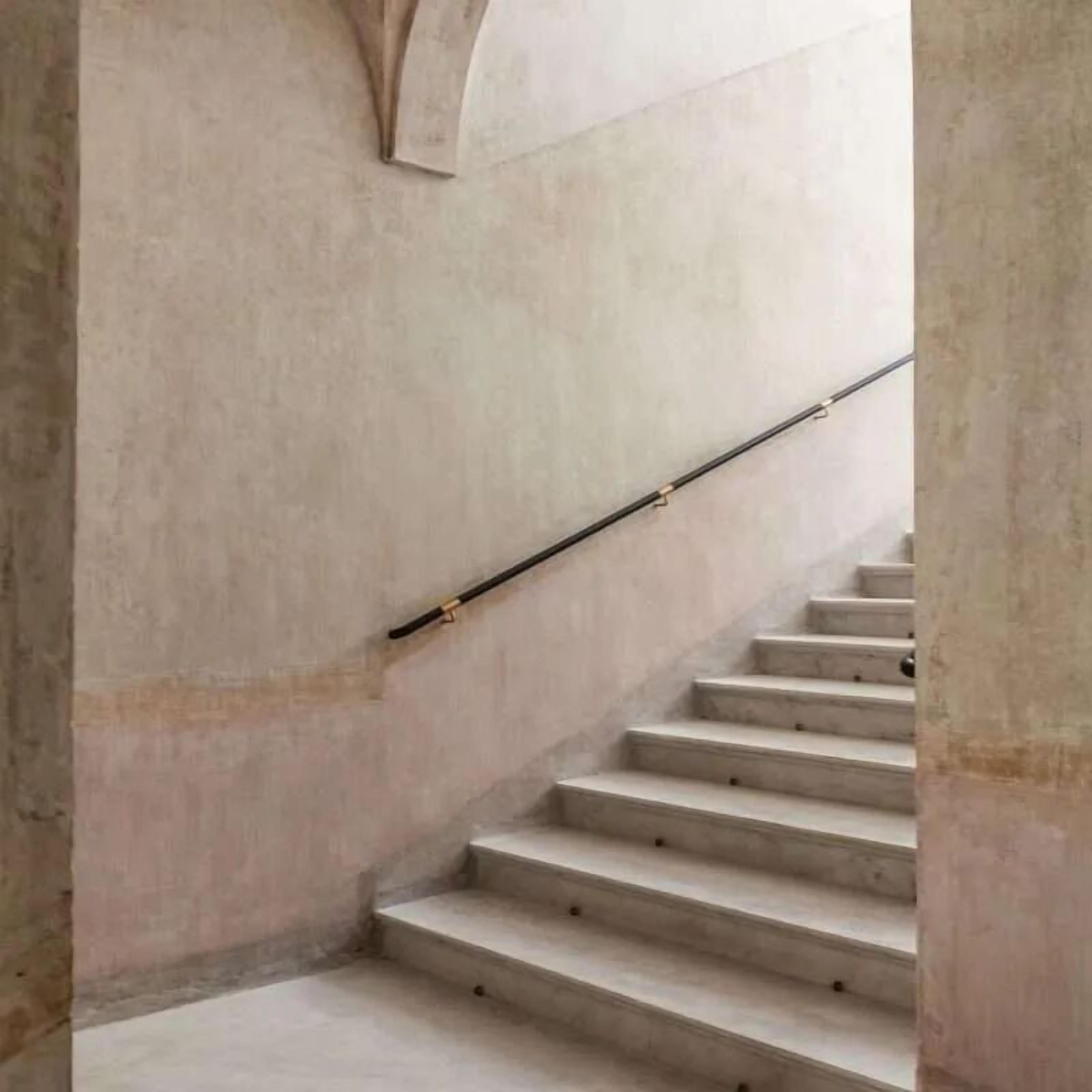 A staircase with a handrail, leading upwards.