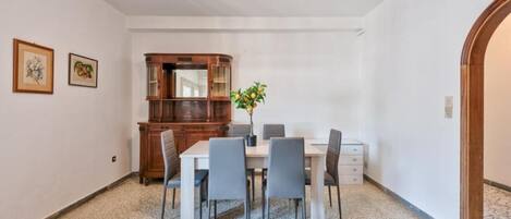 A dining area with a wooden cabinet, a table, and six chairs.