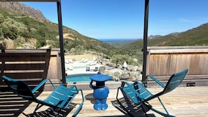 A poolside area with lounge chairs and a view of a mountainous landscape. - DOMAINE HÔTEL A FLATTA (Calenzana)