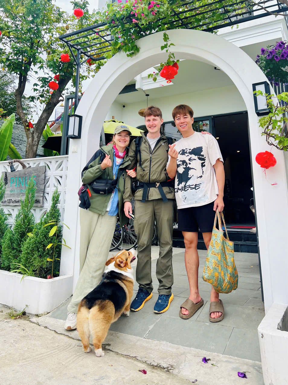 A white arched entrance with a dog and two people standing in front.