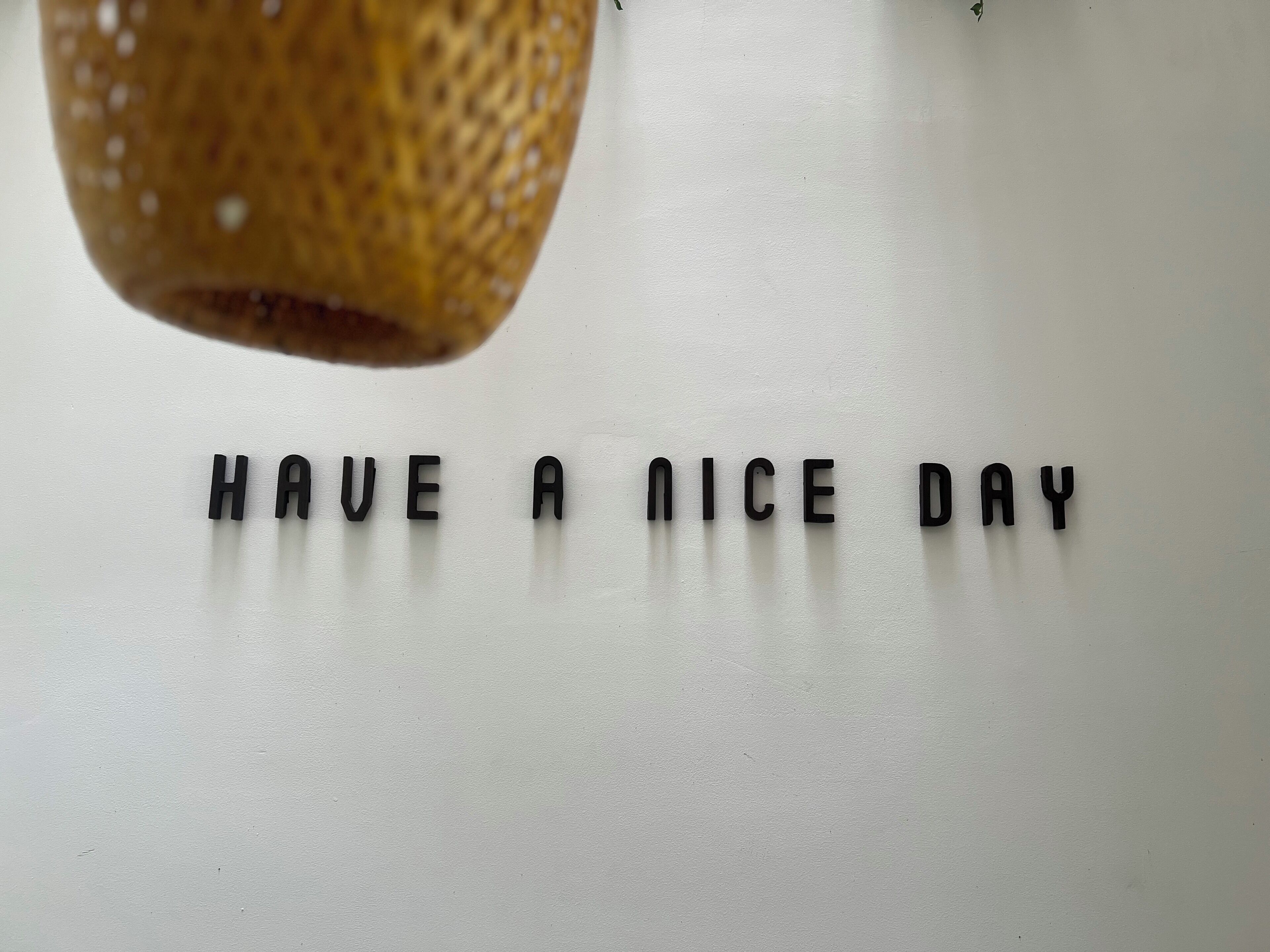 En hvid overflade med ordene "HAVE A NICE DAY" skrevet i sort.
