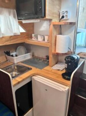 Fridge, microwave, coffee/tea maker, cookware/dishes/utensils