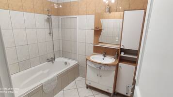 Un bagno moderno con una vasca, un lavandino e un mobile bagno con specchio.