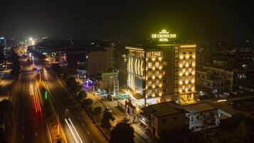 A hotel with a prominent sign, multiple floors, and a well-lit facade.