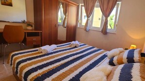 A bedroom with a bed, a desk, and a chair.