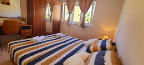 Un dormitorio con cama, escritorio y silla.