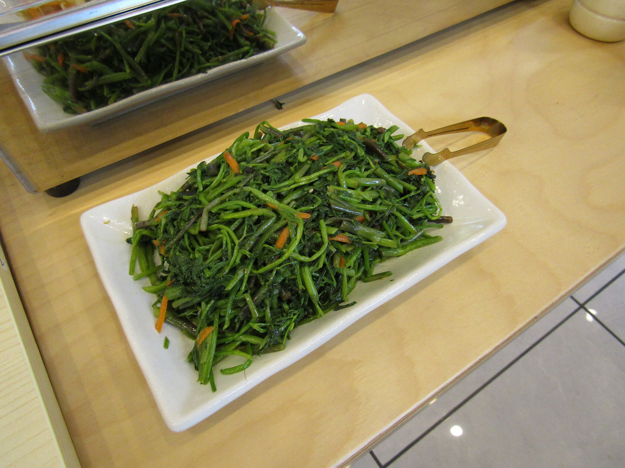 A plate of stir-fried vegetables on a white rectangular plate.
