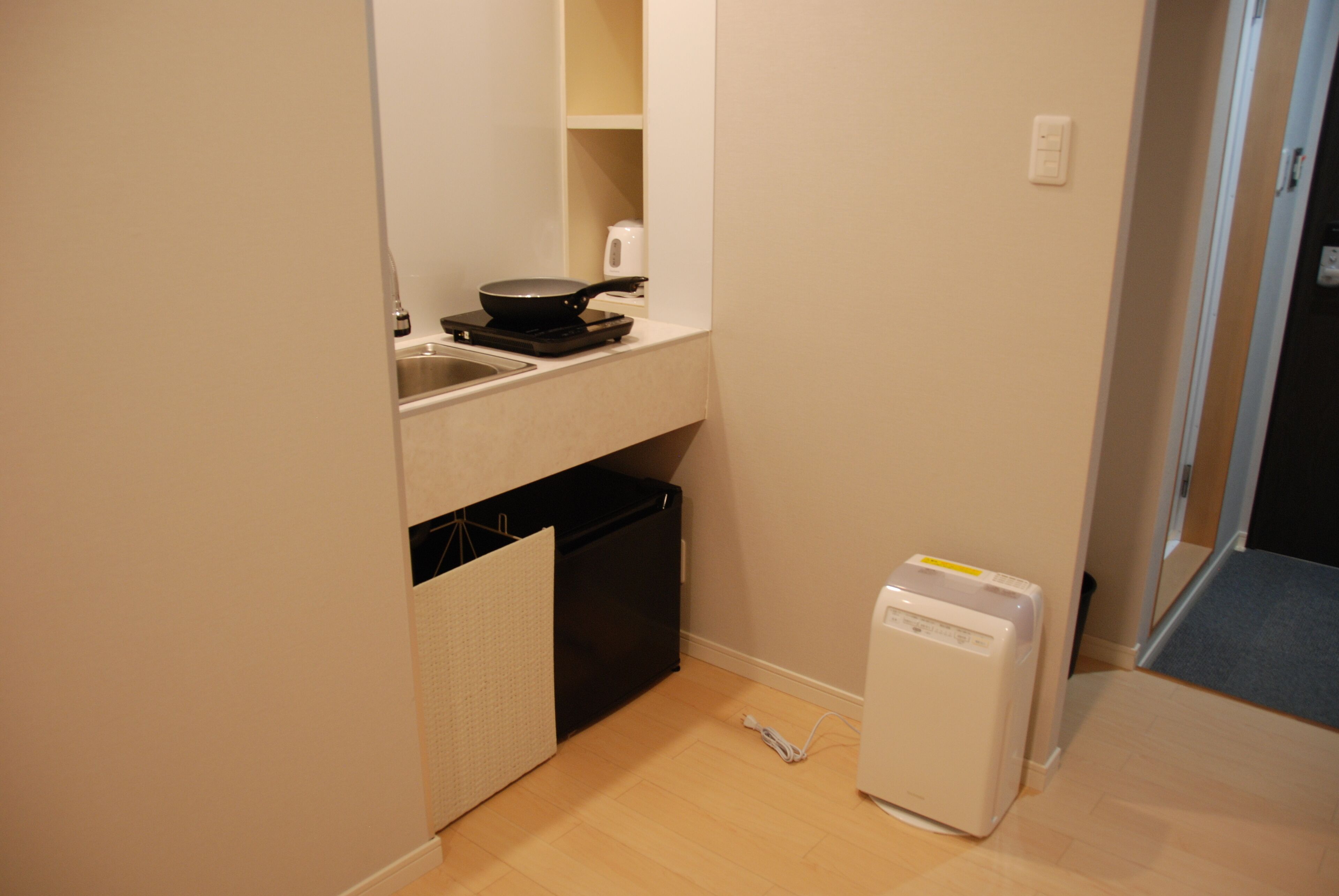 Una cocina pequeña con un lavamanos, estufa compacta y refrigerador pequeño.
