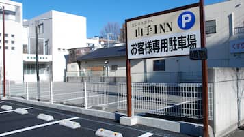 A parking sign for a hotel with a white building in the background.