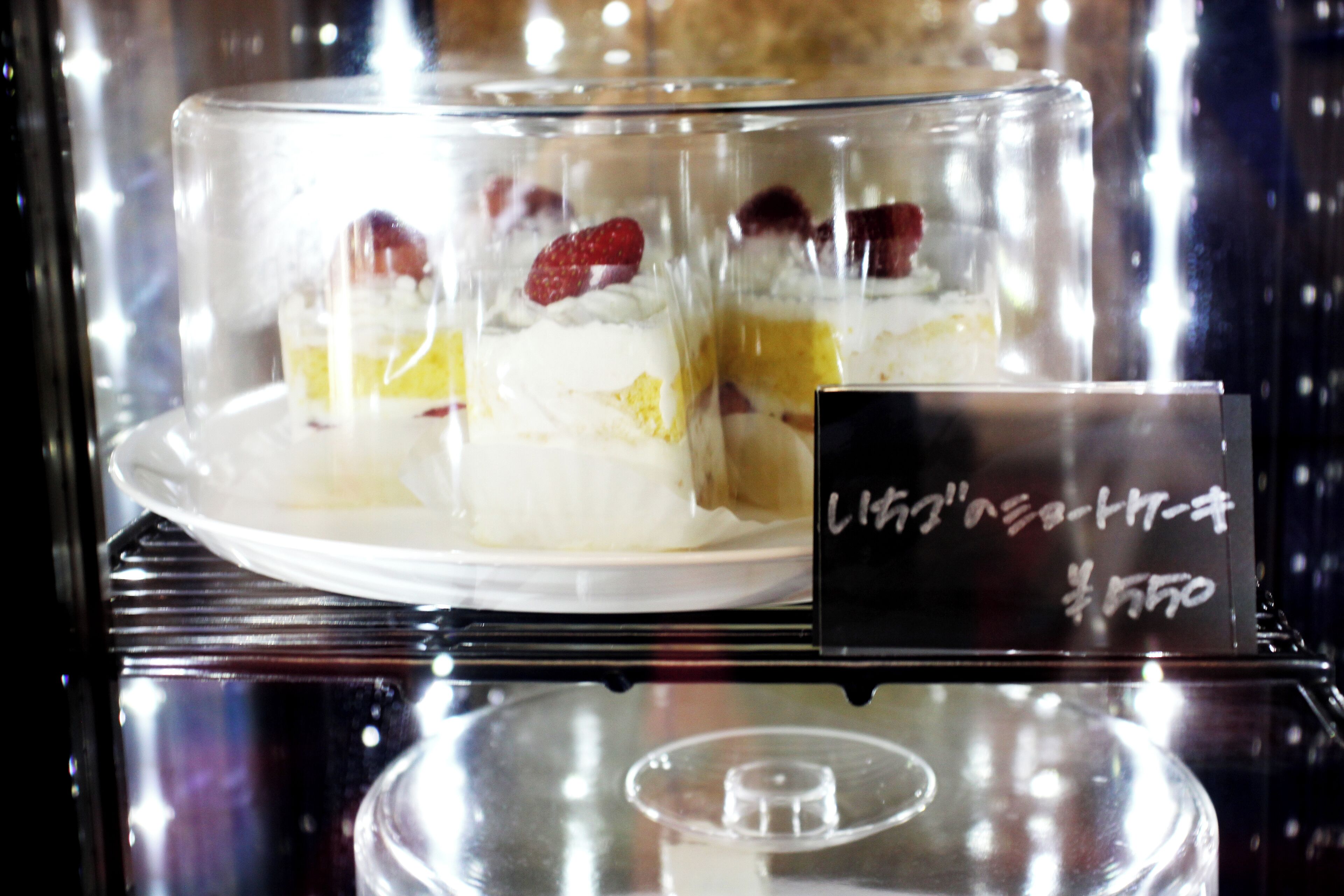 A dessert display case with a sign indicating a price of 550 yen.