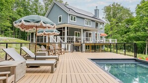 A house with a deck, a swimming pool, and outdoor furniture. - Beautiful Home in Stone Ridge (Stone Ridge)