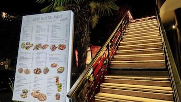 Un cartel de menú de restaurante con una escalera que lleva a la entrada.