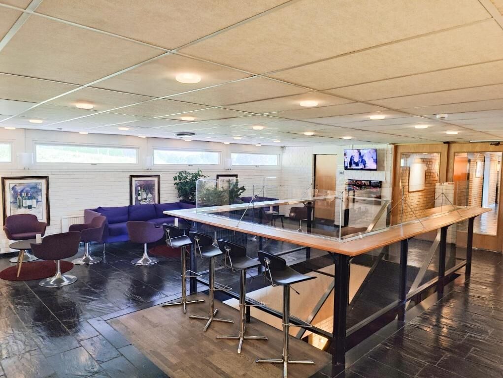 Ein stilvoller Lounge-Bereich mit Bar, Sitzgelegenheiten und Fernseher.