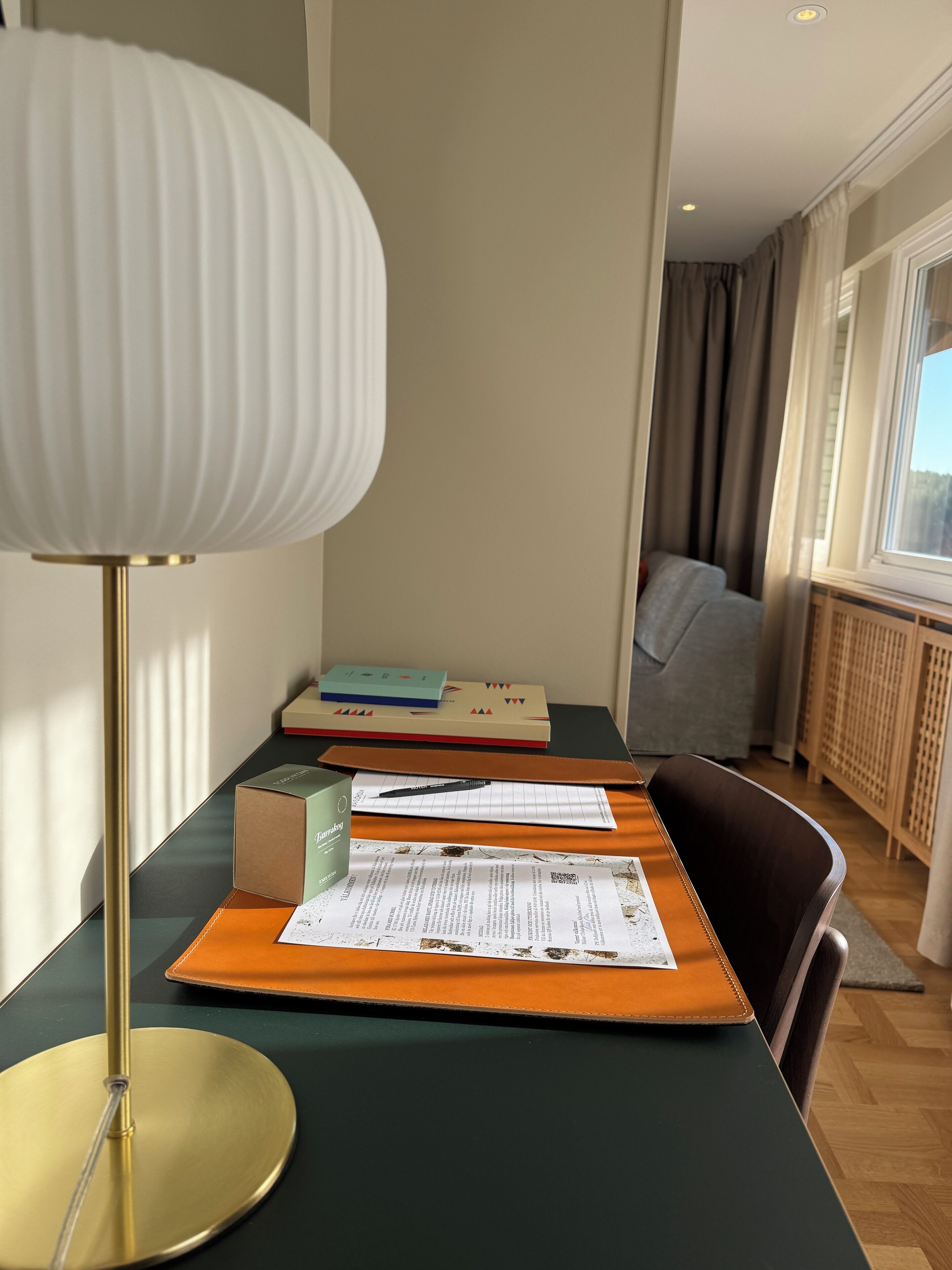 A room with a desk, a lamp, and a window.
