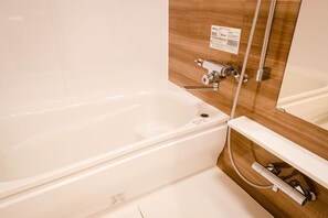 独立的浴缸和淋浴、吹风机、拖鞋、毛巾