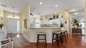 A kitchen with a central island, white cabinetry, and a chandelier.