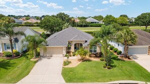 A residential neighborhood with single-family homes, well-maintained lawns, and palm trees.