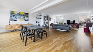 Un salón espacioso con mesa de comedor, sofá y televisor.