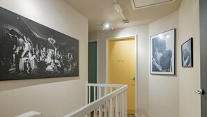 A hallway with a large black-and-white photograph on the left, a door labeled 'Wall Smith' in the center, and two smaller black-and-white photographs on the right. - Amsterdam Group Villa | 20+ | Spa | Karaoke (Zwanenburg)