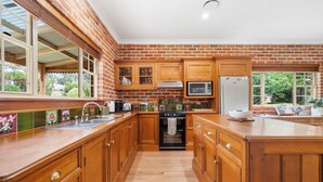 A kitchen with wooden cabinets, a stainless steel sink, a microwave, and a refrigerator. - 6 Minutes from Bathurst CBD - The Estait Homestead - Laffing Waters Retreat (Laffing Waters)