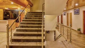 A staircase with metal railings leading to an upper floor. - Hotel Grand Oasis (Manali)