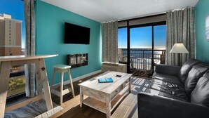 Un salon moderne avec un mur de couleur turquoise, un canapé en cuir noir, une table basse en bois et une grande fenêtre donnant sur la ville.