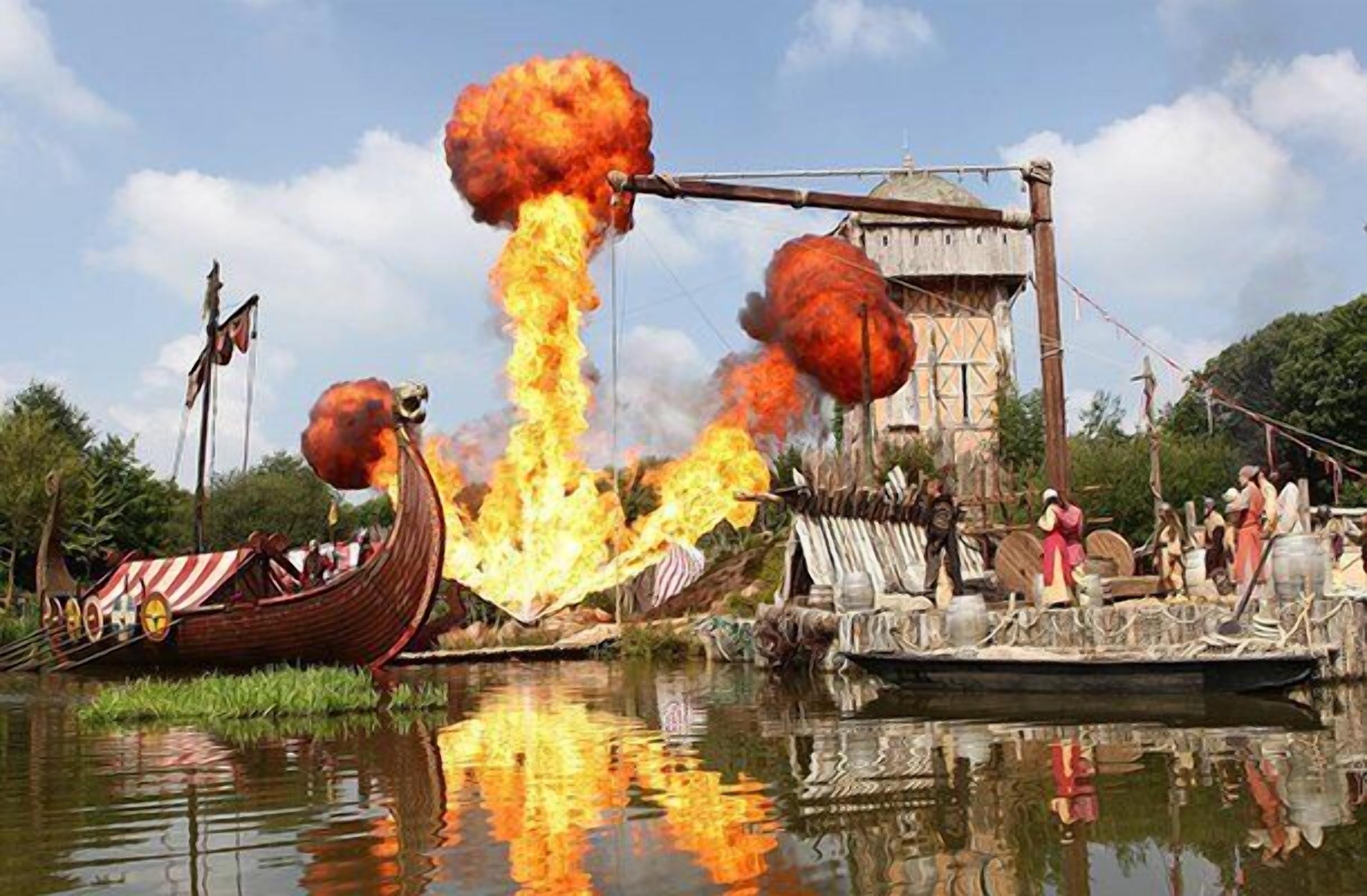A traditional boat with a large fireball explosion, a wooden structure, and a dock with people.