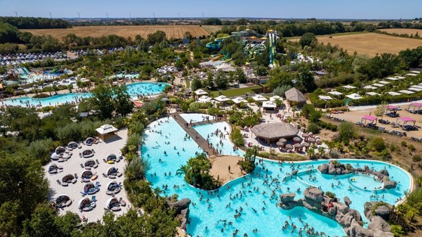 A large outdoor swimming pool complex with multiple pools, a water slide, and surrounding amenities. - Moulin Vert, village house with swimming pool (Talmont-Saint-Hilaire)