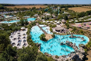 A large outdoor swimming pool complex with multiple pools, a water slide, and surrounding amenities. - Moulin Vert, village house with swimming pool (Talmont-Saint-Hilaire)