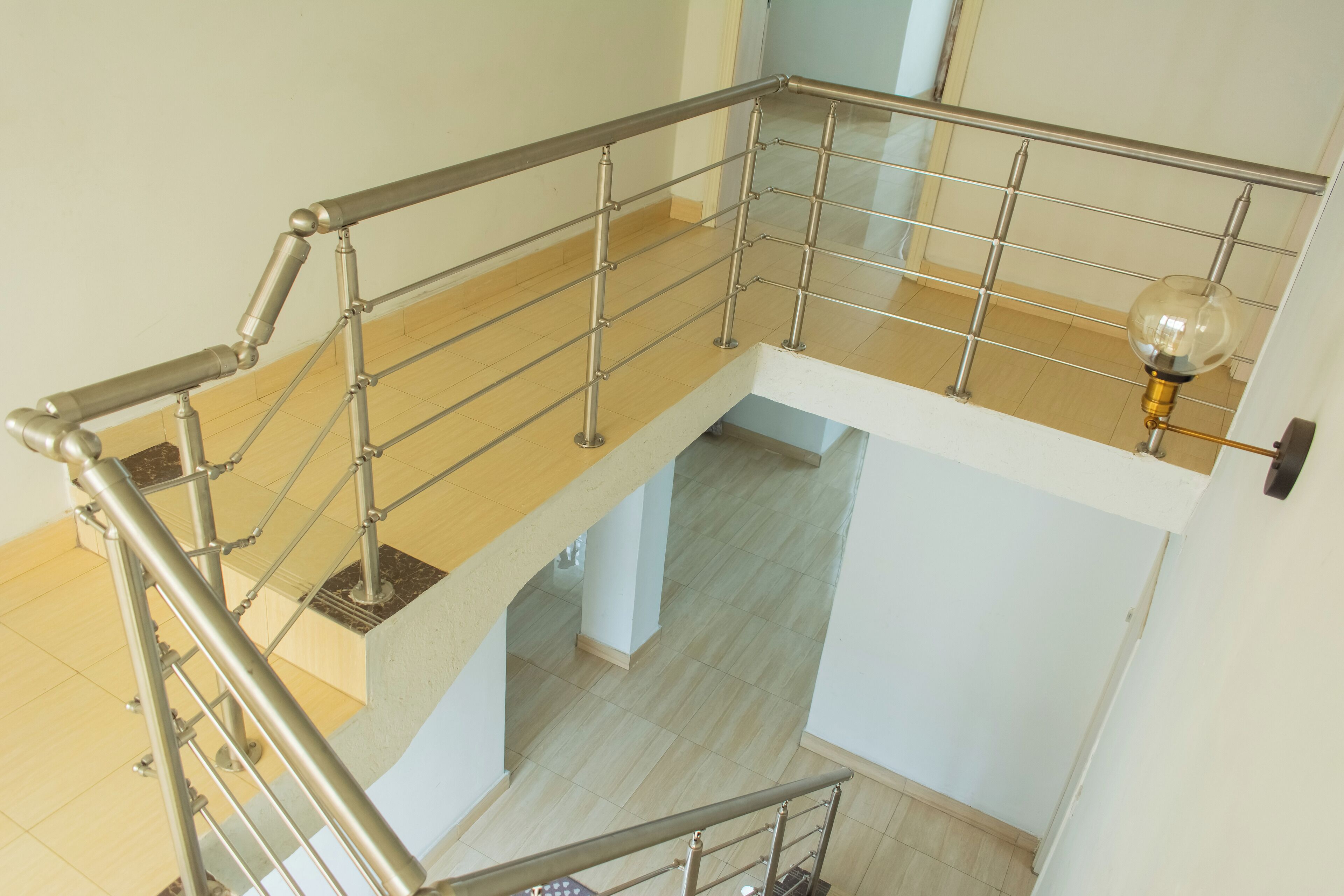 A multi-level interior with metal railings and a light fixture.