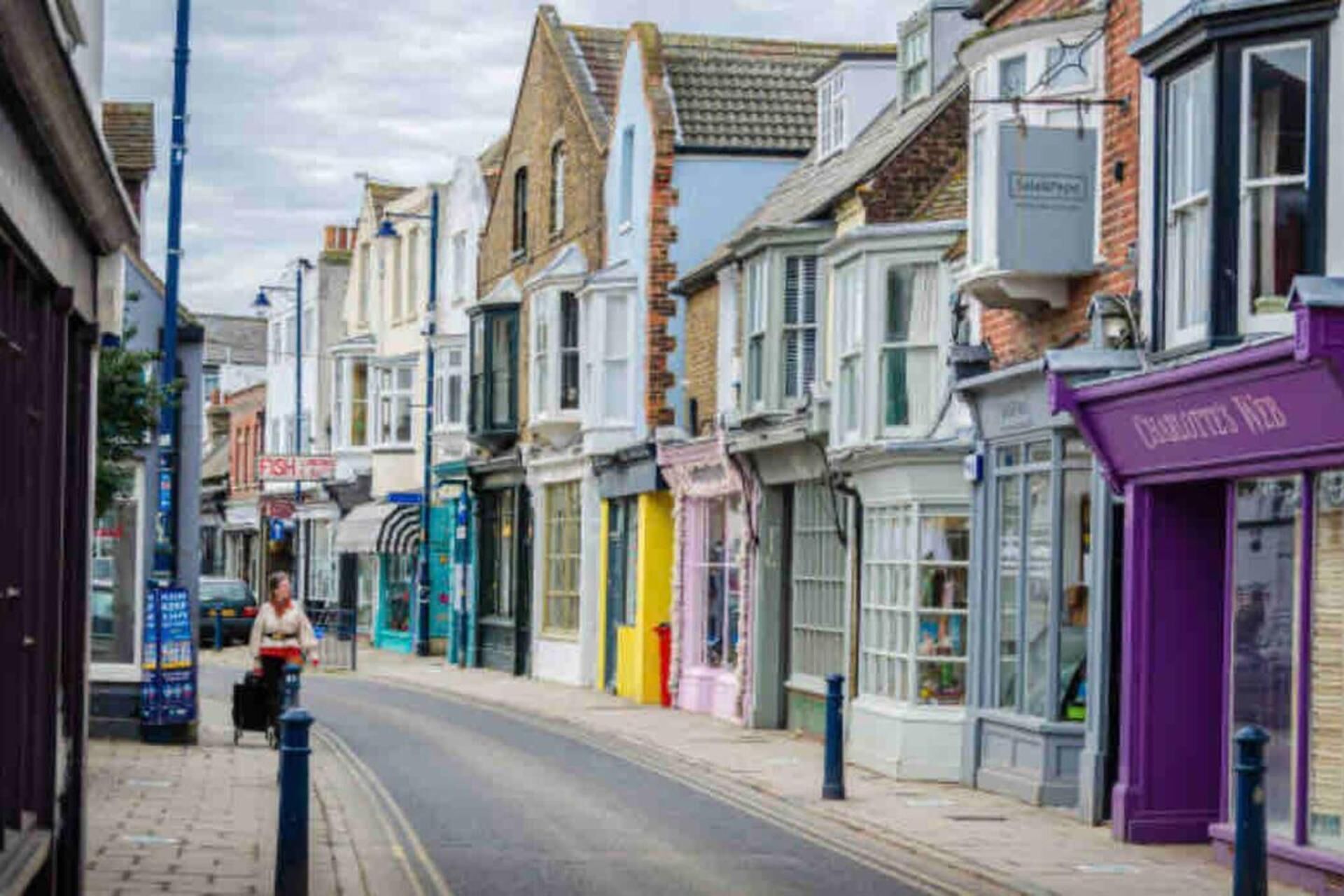 A street with buildings, including a shop with a purple awning and a sign that reads "Fish."