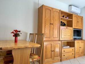Enjoy meals at the dining table with two chairs, accompanied by a vase with flowers.